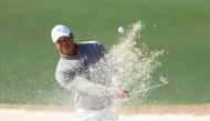  Tiger Woods of the United States plays a shot from a bunker on the 18th hole during the continuation of the first round of the 2024 Masters Tournament at Augusta National Golf Club on April 12, 2024 in Augusta, Georgia. (Photo by Warren Little / GETTY IMAGES NORTH AMERICA / Getty Images via AFP)
