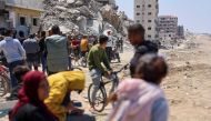 People wait on April 14, 2024, for displaced Palestinians returning to Gaza City after fleeing northern Gaza following hostilities. Photo by AFP.