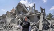 A woman reacts as she stands amidst rubble before a collapsed building in the eastern side of the Maghazi camp for Palestinian refugees in the central gaza Strip on April 15, 2024. (Photo by AFP)
