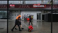 Formula One team members walk next to the paddock at the Shanghai International circuit ahead of the Formula One Chinese Grand Prix in Shanghai on April 17, 2024. (Photo by HECTOR RETAMAL / AFP)

