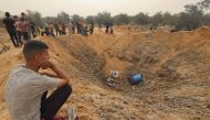 Palestinians gather around a huge crater following overnight Israeli bombardment in Rafah in the southern Gaza Strip on April 18, 2024. (Photo by Mohammed Abed / AFP)