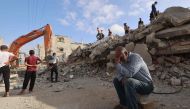 A Palestinian man wait for news of his daughter as rescue workers search for survivors under the rubble of a building hit in an overnight Israeli bombing in Rafah, in the southern Gaza Strip, on April 21. (Photo by MOHAMMED ABED / AFP)