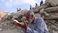 A Palestinian man wait for news of his daughter as rescue workers search for survivors under the rubble of a building hit in an overnight Israeli bombing in Rafah, in the southern Gaza Strip, on April 21, 2024. (Photo by Mohammed Abed / AFP)