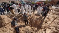 Palestinian health workers dig for bodies buried by Israeli forces in Nasser hospital compound in Khan Yunis in the southern Gaza Strip on April 21, 2024, as battles continue between Hamas militants and Israeli forces in the besieged Palestinian territory. (Photo by AFP)
