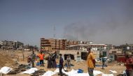 People and health workers unearth bodies found at Nasser Hospital in Khan Yunis in the southern Gaza Strip on April 23, 2024. (Photo by AFP)