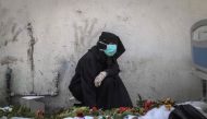 A woman mourns by a body unearthed at Nasser Hospital in Khan Yunis in the southern Gaza Strip on April 23, 2024. (Photo by AFP)
