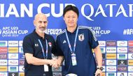 Iraq coach Radhi Shenaishil (left) and Japan coach Go Oiwa shake hands at a press conference yesterday. AFC 