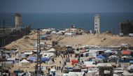 People walk in a camp for displaced people in Rafah in the southern Gaza Strip by the border with Egypt on April 28, 2024. (Photo by AFP)