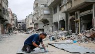 A Palestinian man fixes tin sheets used for temporary sheltering on a road lined with destroyed buildings in Khan Yunis in the southern Gaza Strip on May 2, 2024, amid the ongoing conflict between Israel and the Hamas movement. Photo by AFP.