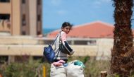 Displaced Palestinians who left with their belongings from rafah in the southern Gaza Strip following an evacuation order by the Israeli army, unload their belongings to set up shelter in Khan Yunis on May 6, 2024. (Photo by AFP)
