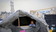 A Palestinian boy looks out his tent in a Rafah displacement camp in the southern gaza Strip on May 13, 2024 (Photo by AFP)