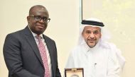 QU President Dr. Omar Al Ansari (right) during the signing of the agreement with one of the officials. 