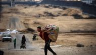 Palestinians carry their belongings as they prepare to flee rafah in the southern Gaza Strip on May 13, 2024. (Photo by AFP)