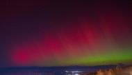 (Files) The Aurora Australis, also known as the Southern Lights, glow on the horizon as seen from Ushuaia, Tierra del Fuego, Argentina on May 10, 2024. (Photo by Alexis Delelisi / AFP)