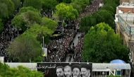 This grab taken from handout video footage released by Iran Press on May 21, 2024 shows people gathering to mourn during a funeral procession in the northwestern city of Tabriz, the capital of East Azerbaijan province. (Photo by Iran Press / AFP) 