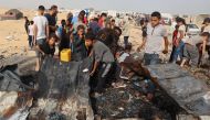 Palestinians gather at the site of an Israeli strike on a camp for internally displaced people in Rafah on May 27, 2024. (Photo by Eyad Baba / AFP)