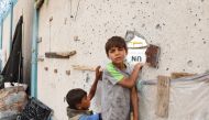 Palestinian boys stand near a damaged structure at the site of an Israeli strike a day earlier on a camp for internally displaced people in Rafah in the southern Gaza Strip on May 28, 2024.(Photo by Eyad Baba / AFP)