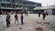 Palestinian boys stand near blood stain at a UN-school housing displaced people that was hit during Israeli bombardment in Nuseirat, in the central Gaza Strip, on June 6, 2024. Photo by Bashar TALEB / AFP