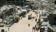 Stalls set-up by vendors close to the ruins of destroyed buildings in the Jabalia refugee camp on June 7, 2024. (Photo by Omar Al-Qattaa / AFP)