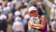 Poland's Iga Swiatek celebrates with the trophy after winning against Italy's Jasmine Paolini at the end of women's singles final match on Court Philippe-Chatrier on day fourteen of the French Open tennis tournament at the Roland Garros Complex in Paris on June 8, 2024. Photo by Emmanuel Dunand / AFP.