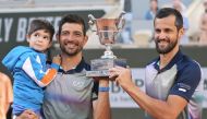 Salvador's Marcelo Arevalo (2ndL) and Croatia's Mate Pavic celebrate after winning against Italy's Simone Bolelli and Andrea Vavassori at the end of their men's doubles final match on Court Philippe-Chatrier on day fourteen of the French Open tennis tournament at the Roland Garros Complex in Paris on June 8, 2024. (Photo by Bertrand GUAY / AFP)
