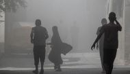 Palestinians walk through smoke and dust following an operation by the Israeli Special Forces in the Nuseirat camp, in the central Gaza Strip on June 8, 2024. (Photo by Bashar Taleb / AFP)