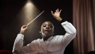 South African conductor Ofentse Pitse waves her conducting baton during rehearsals at Marks Park Sports Club in Johannesburg on June 4, 2024 as they prepare for a show that brings together classical music and popular South African genre, Amapiano. Photo by Phill Magakoe / AFP.