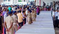 Policemen stand guard as mourning relatives await coffins of the deceased arriving on an Indian Air Force plane from Kuwait at the Cochin International Airport in Kochi on June 14, 2024. (Photo by Arun Chandrabose / AFP)