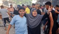 A woman reacts as people look for survivors following Israeli bombardment at al-Bureij refugee camp in the central Gaza Strip on June 16, 2024. (Photo by Eyad Baba / AFP)