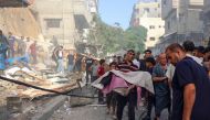 A man holds the body of a person recovered from the rubble of a building following Israeli bombardment at al-Bureij refugee camp in the central Gaza Strip on June 15, 2024. (Photo by Eyad BABA / AFP)
