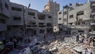 Palestinians search the rubble of the Harb family home which was hit in overnight Israeli strikes in al-Bureij refugee camp in the central Gaza Strip, on June 18, 2024. (Photo by Bashar Taleb / AFP)
 