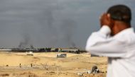 Smoke from Israeli bombardment billows in the background near an area previously housing displaced Palestinians leaving Rafah towards Khan Yunis on June 20, 2024, in the southern Gaza Strip. (Photo by Bashar TALEB / AFP)
