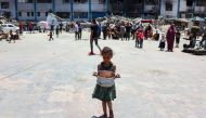 A child carries food at a UN Relief and Works Agency for Palestine Refugees (UNRWA) school in the Jabalia camp for Palestinian refugees in the northern Gaza Strip on June 17, 2024. Photo by Omar AL-QATTAA / AFP.