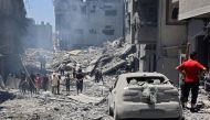 People inspect the damage next to a building destroyed during Israeli bombardment at al-Shati refugee camp in Gaza City on June 22, 2024. (Photo by Omar Al-Qattaa / AFP)