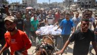 Palestinians transport the bodies of loved ones killed during Israeli bombardment for burial in al-Tuffah neighbourhood in Gaza City on June 22, 2024. (Photo by Omar AL-QATTAA / AFP)
