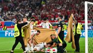 Players and stewards hold a cloth as Hungary's forward #19 Barnabas Varga (down) falls after a collision during the UEFA Euro 2024 Group A football match on June 23, 2024. (Photo by Miguel Medina / AFP)
