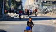 A boy carries water al-Bureij refugee camp in the central Gaza Strip on June 24, 2024. (Photo by Eyad Baba / AFP)