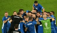 Slovenia's players celebrate qualifying for the knock-out stages on the pitch after the UEFA Euro 2024 Group C football match between England and Slovenia at the Cologne Stadium in Cologne on June 25, 2024. (Photo by Angelos Tzortzinis / AFP)