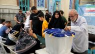 An Iranian man casts his ballot during voting at a polling station in Tehran for the Islamic republic's presidential election on June 28, 2024. (Photo by Raheb Homavandi / AFP)