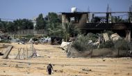 A man walks near a building damaged during Israeli bombardment in Rafah, on the southern Gaza Strip on June 29, 2024. (Photo by Eyad Baba / AFP)