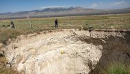 Arif Delikan, an associate professor of Konya Technical University inspects a large sinkhole in Karapinar in the central Anatolian province of Konya, on June 23, 2024. (Photo by Yasin Akgul / AFP)