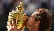 File: Britain's Andy Murray poses with the winner's trophy after his men's singles final victory over Canada's Milos Raonic on the last day of the 2016 Wimbledon Championships at The All England Lawn Tennis Club in Wimbledon, southwest London, on July 10, 2016. (Photo by Glyn Kirk / AFP) 