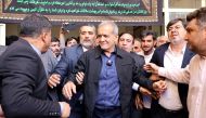 Iranian reformist presidential candidate Masoud Pezeshkian (C) leaves a polling station after voting in Tehran on July 5, 2024. (Photo by Atta Kenare / AFP)