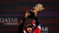 Mercedes' British driver Lewis Hamilton celebrates with the trophy on the podium after winning the Formula One British Grand Prix at the Silverstone motor racing circuit in Silverstone, central England, on July 7, 2024. (Photo by BENJAMIN CREMEL / AFP)
