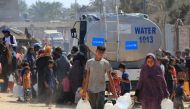 Palestinians collect water from a UNICEF tanker in Deir el-Balah in the central Gaza Strip on July 9, 2024. (Photo by Eyad BABA / AFP)
