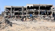 Palestinians stand in front of destroyed buildings and rubble after the Israeli military withdrew from the Shujaiya neighbourhood, east of Gaza City on July 10, 2024. (Photo by Omar Al-Qattaa / AFP)