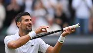 Serbia's Novak Djokovic imitates playing the violin with his racquet as he celebrates winning against Italy's Lorenzo Musetti during their men's singles semi-final tennis match on the twelfth day of the 2024 Wimbledon Championships at The All England Lawn Tennis and Croquet Club in Wimbledon, southwest London, on July 12, 2024. (Photo by ANDREJ ISAKOVIC / AFP) / RESTRICTED TO EDITORIAL USE