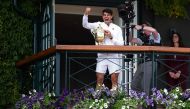 Spain's Carlos Alcaraz celebrates with the winner's trophy as he shows it to the crowd from the Centre Court balcony after winning against Serbia's Novak Djokovic during their men's singles final tennis match on the fourteenth day of the 2024 Wimbledon Championships at The All England Lawn Tennis and Croquet Club in Wimbledon, southwest London, on July 14, 2024. (Photo by HENRY NICHOLLS / AFP)
