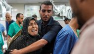 A man comforts a woman as she reacts at a trauma ward at Nasser Medical Complex in Khan Yunis in the southern Gaza Strip on July 16, 2024. (Photo by Bashar TALEB / AFP)
