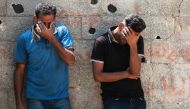 Palestinians cry during the funeral of a casualty of Israeli bombardment in Khan Yunis in the southern Gaza Strip on July 16, 2024. (Photo by Bashar Taleb / AFP)

